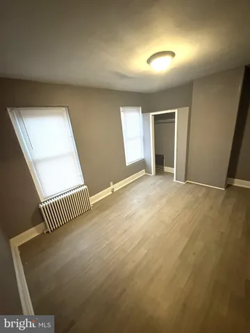 an empty room with wooden floor and glass door