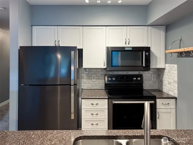 a kitchen with a refrigerator stove and microwave
