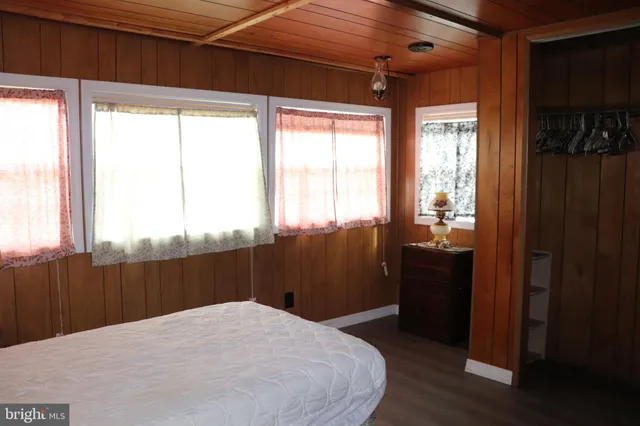a large bed in a bedroom next to a window and a bathroom