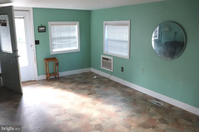 an empty room with a window and wooden floor