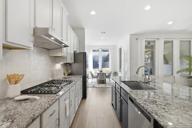 a kitchen with stainless steel appliances granite countertop a sink stove and refrigerator