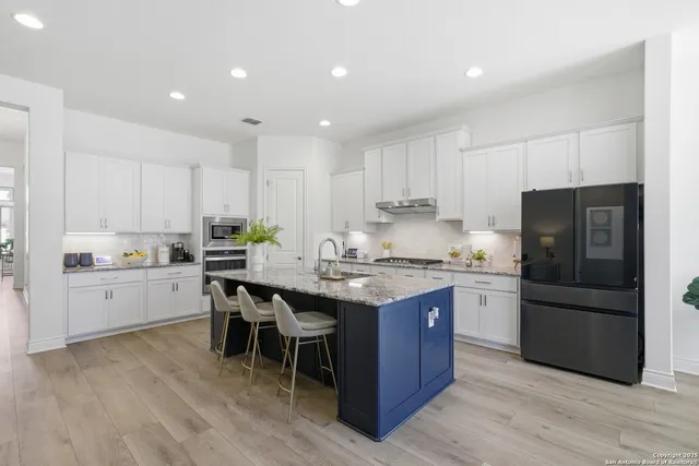 a kitchen with granite countertop a sink appliances a counter space and cabinets