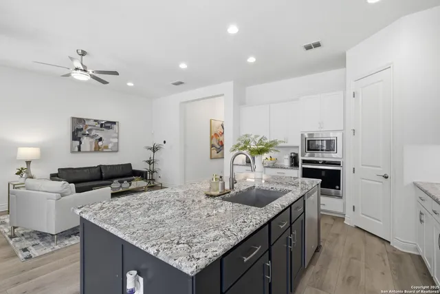 a kitchen with granite countertop kitchen island a counter space and stainless steel appliances