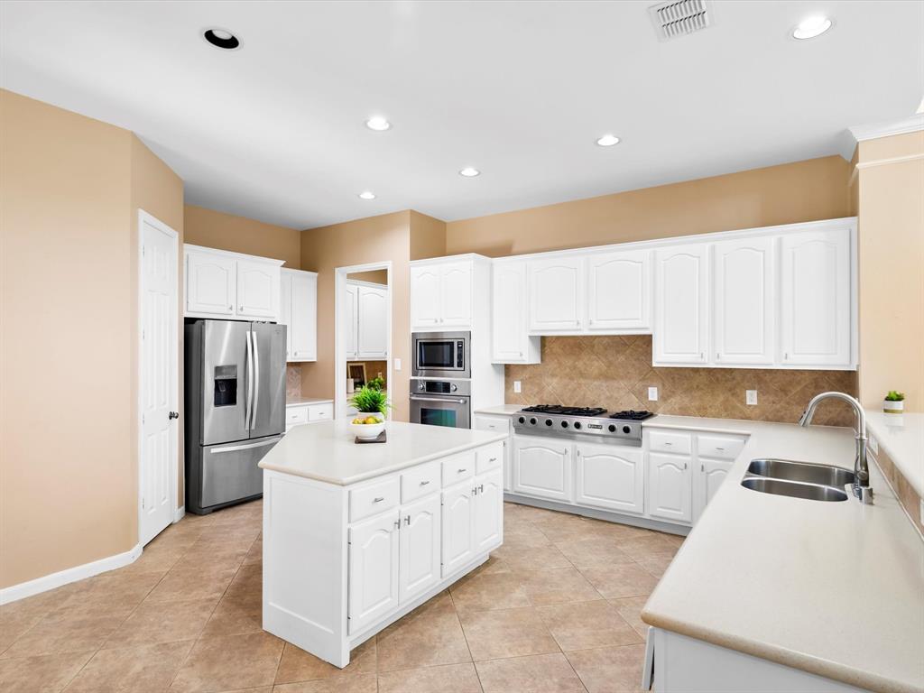 728 Morningside Trail Murphy, TX 75094 - Photo 11 of 40 a kitchen with a sink stainless steel appliances and white cabinets