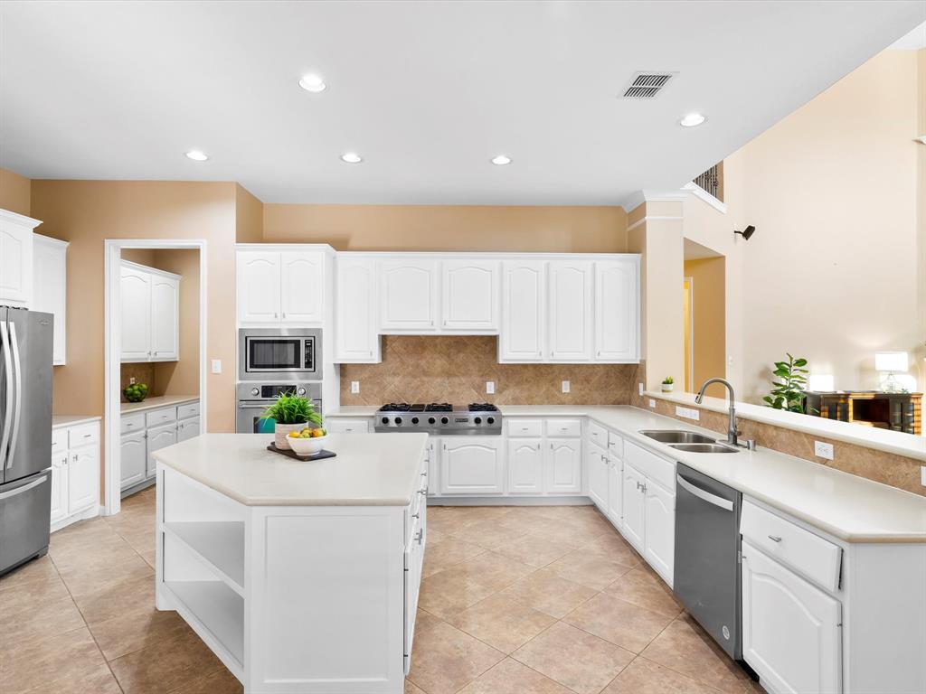 728 Morningside Trail Murphy, TX 75094 - Photo 9 of 40 a kitchen with stainless steel appliances a stove a sink a refrigerator a center island and a cabinets