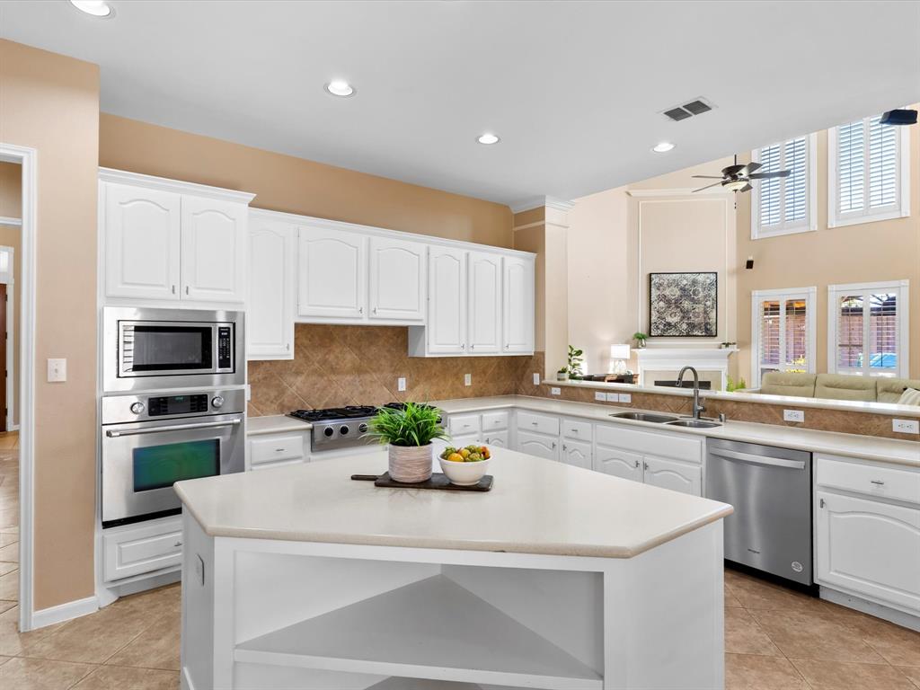 728 Morningside Trail Murphy, TX 75094 - Photo 10 of 40 a kitchen with white cabinets and stainless steel appliances
