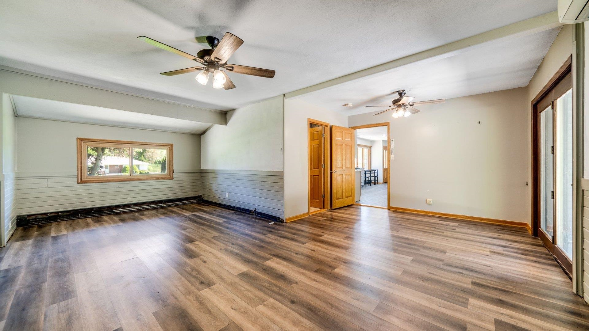 313 West Margaret Fuller Road Oregon, IL 61061 - Photo 17 of 46 an empty room with wooden floor chandelier fan and windows