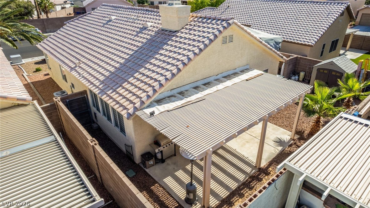5112 West Camino Del Rancho Las Vegas, NV 89130 - Photo 37 of 44 This aerial view showcases the home's exterior features, including a tiled roof and inviting patio.