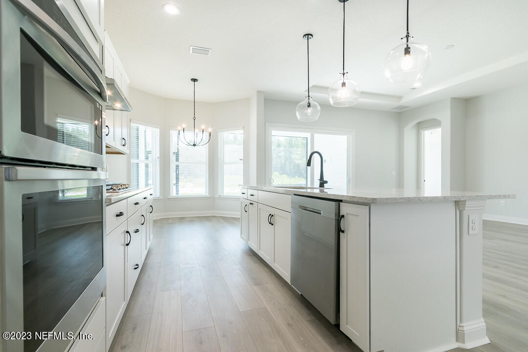 526 Eagle Moon Lake Drive St. Augustine, FL 32092 - Photo 11 of 24 a large white kitchen with cabinets a sink a window and stainless steel appliances