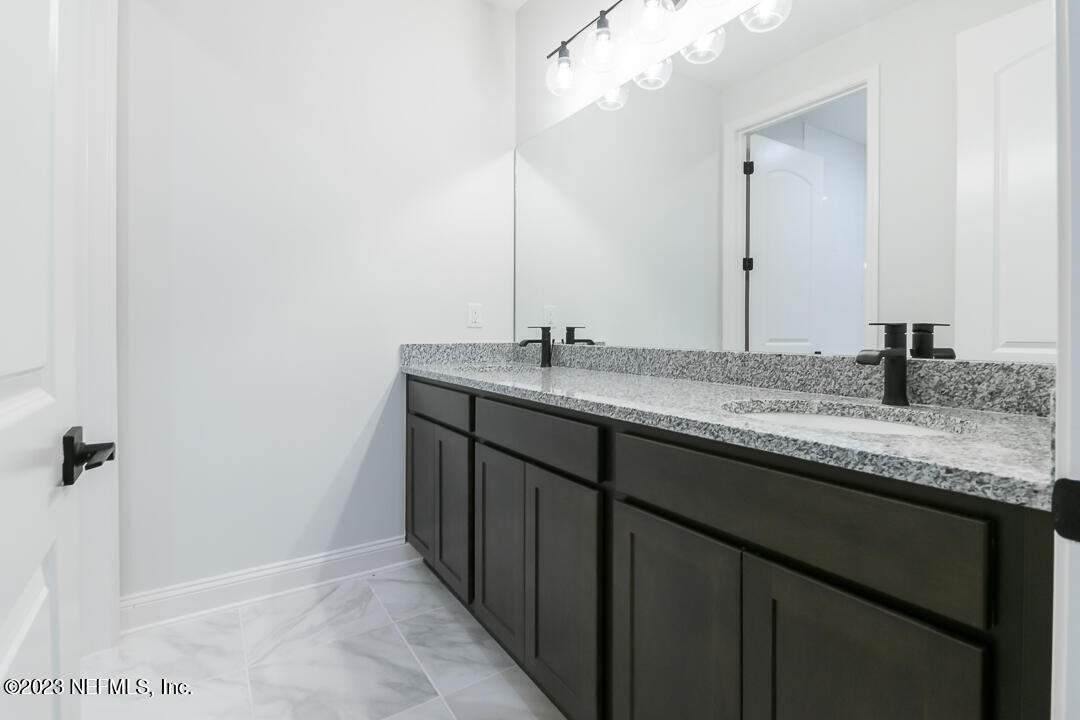 526 Eagle Moon Lake Drive St. Augustine, FL 32092 - Photo 18 of 24 a bathroom with a granite countertop sink and a mirror