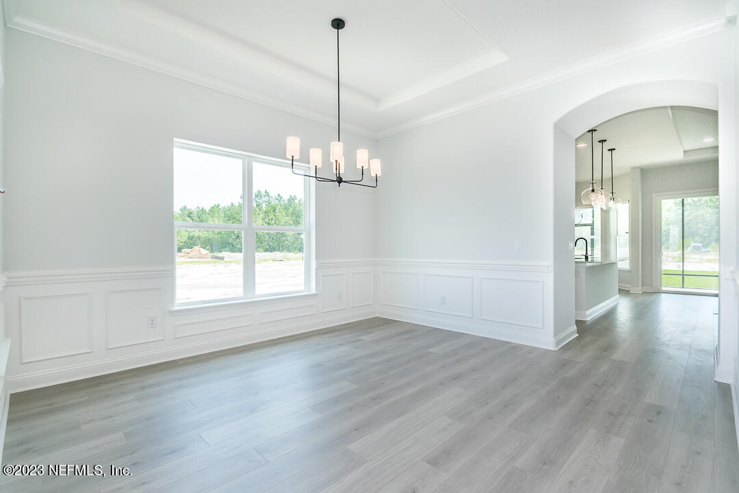 526 Eagle Moon Lake Drive St. Augustine, FL 32092 - Photo 5 of 24 a view of a room with wooden floor chandeliers and kitchen view