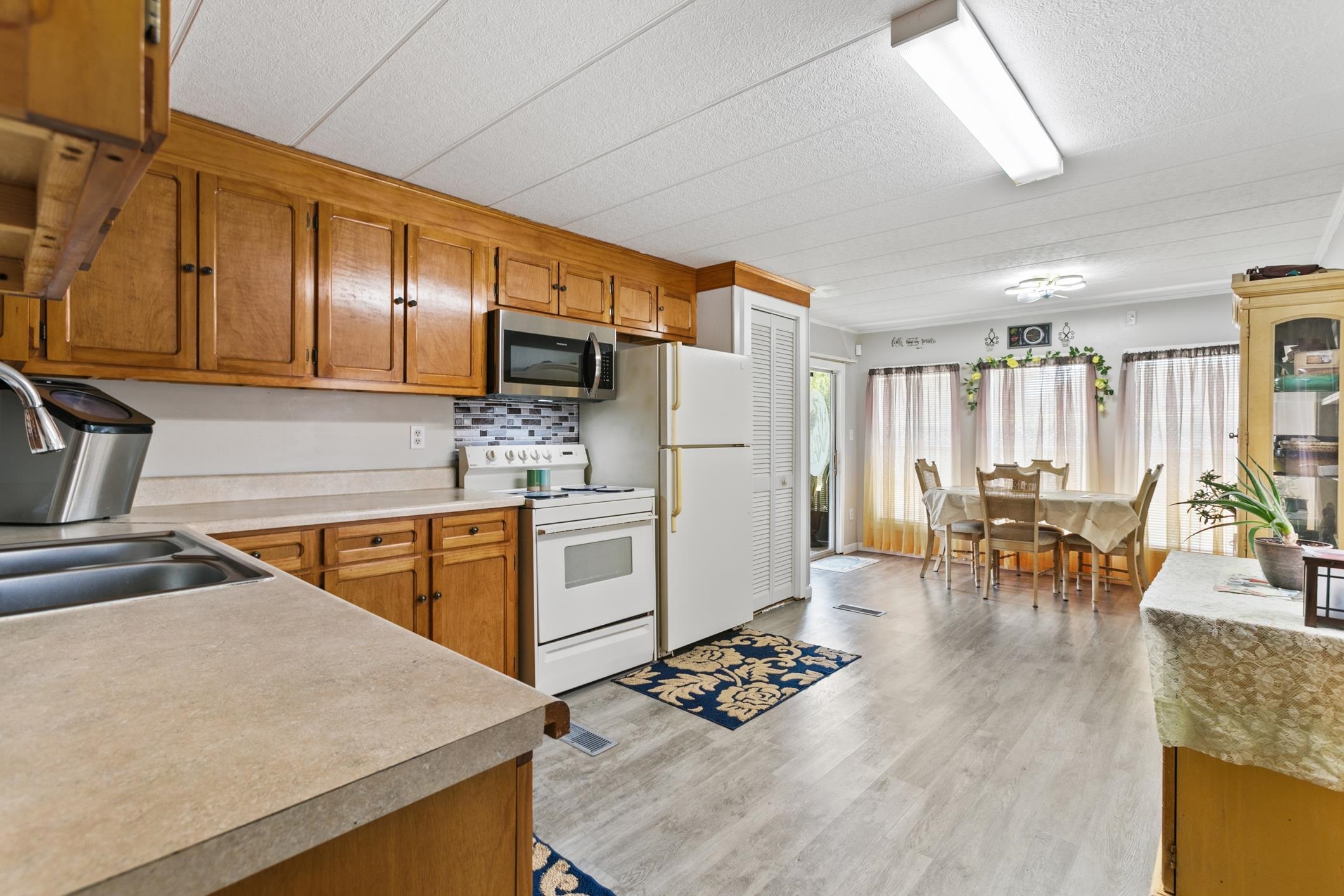 227 Spec Lane Crescent City, FL 32112 - Photo 10 of 24 a kitchen with stainless steel appliances granite countertop a refrigerator a sink dishwasher a stove with white cabinets and wooden floor