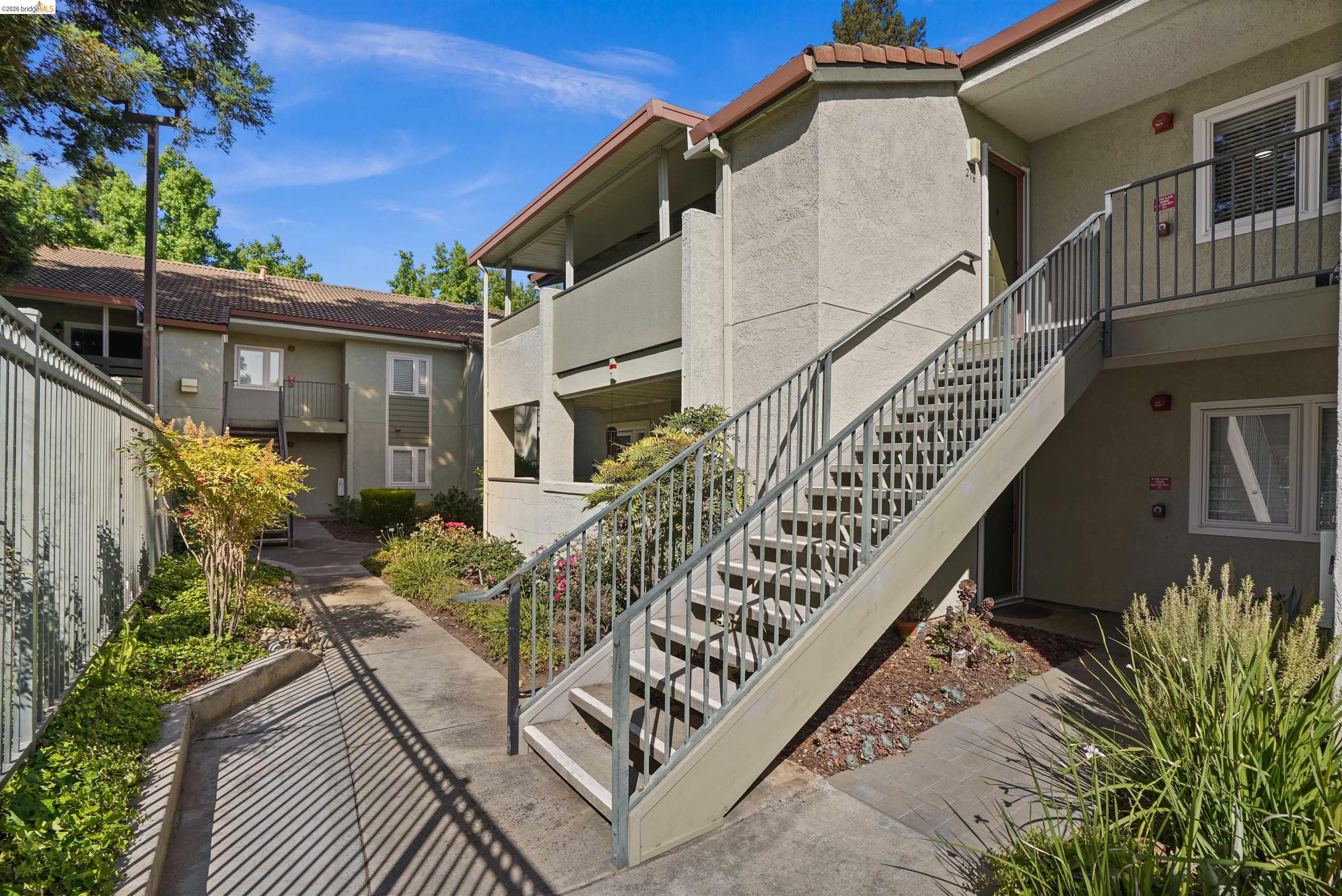 1505 Kirker Pass Road, Unit 214 Concord, CA 94521 - Photo 54 of 55 Exterior building featuring stucco siding, multiple windows, and a prominent outdoor staircase with metal railings