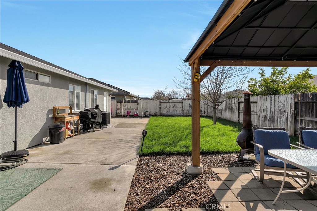 346 Stanton Way Orland, CA 95963 - Photo 36 of 41 a view of a patio with table and chairs a barbeque with wooden fence