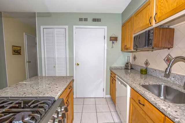 a kitchen with granite countertop a sink stove and refrigerator