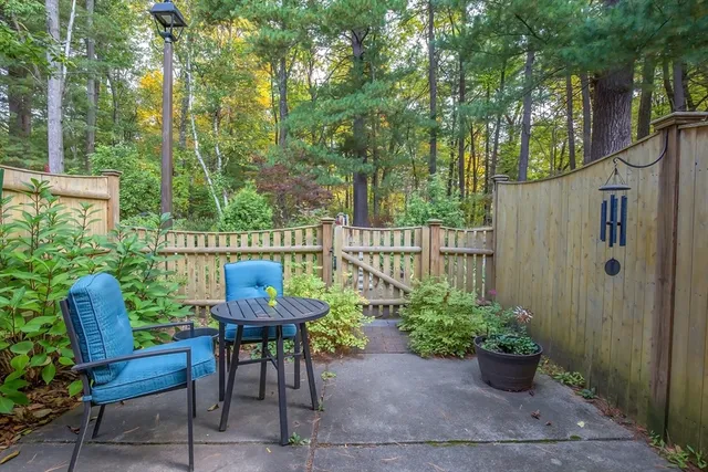 a view of a chair and table in back yard of the house