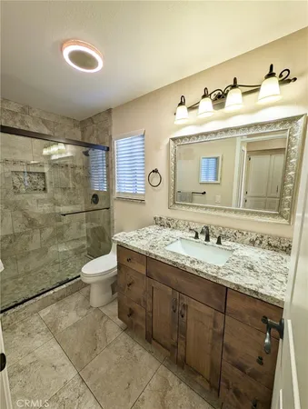 a bathroom with a sink vanity mirror and toilet