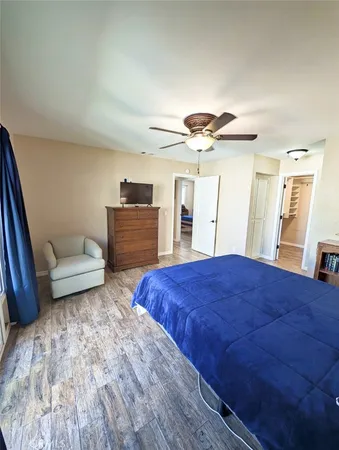 a spacious bedroom with a bed and a dresser