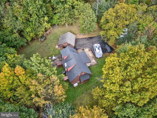 an aerial view of a house with a yard swimming pool and outdoor seating