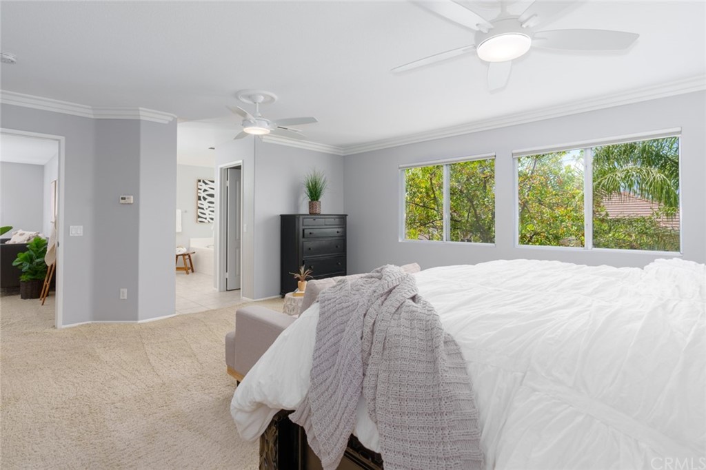 8 Elizabeth Lane Irvine, CA 92602 - Photo 21 of 41 a spacious bedroom with a large bed and a chandelier