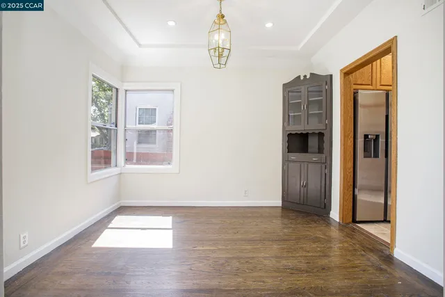 a view of empty room with wooden floor and windows