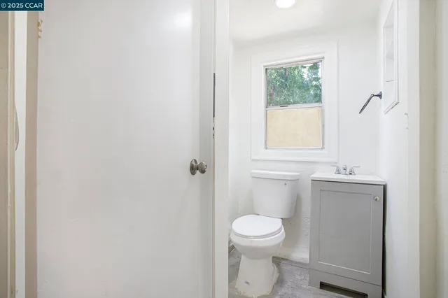 a bathroom with a sink a toilet and a window