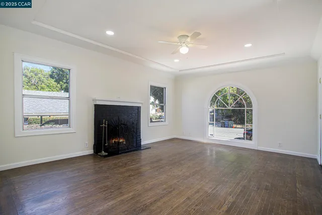 an empty room with windows and fireplace