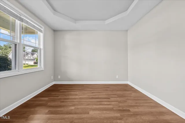 an empty room with windows a fireplace