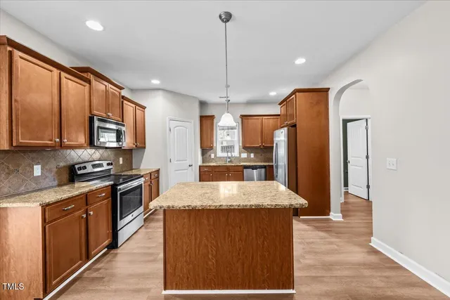 a kitchen with granite countertop a stove and a microwave