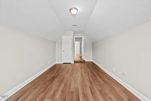 a white toilet sitting next to a white wall
