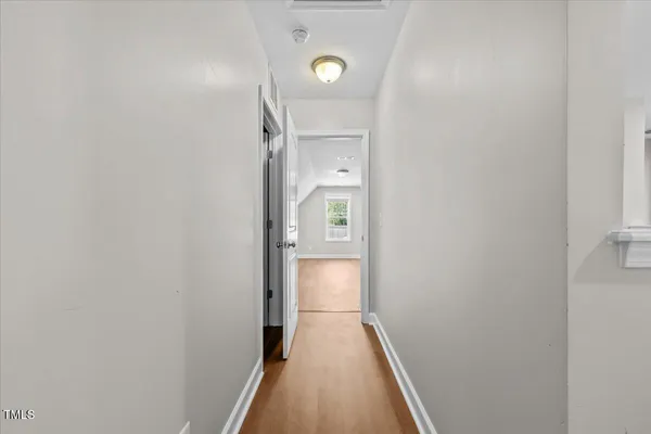 a view of a hallway with wooden floor
