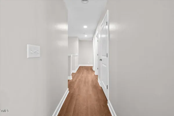 a view of a hallway with wooden floor and staircase