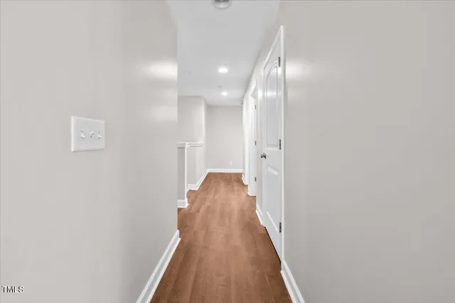 a view of a hallway with wooden floor and staircase