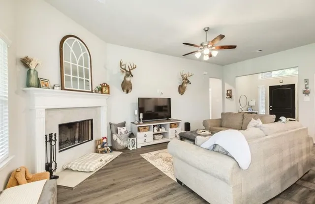 a living room with furniture a fireplace and a flat screen tv