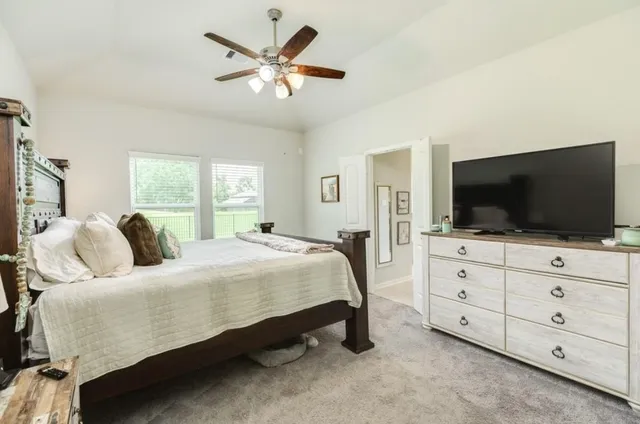 a bedroom with a large bed and a flat screen tv