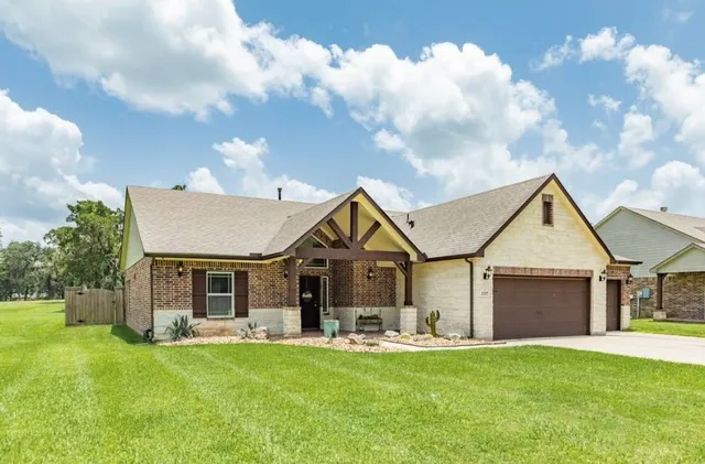 a front view of a house with a garden and yard