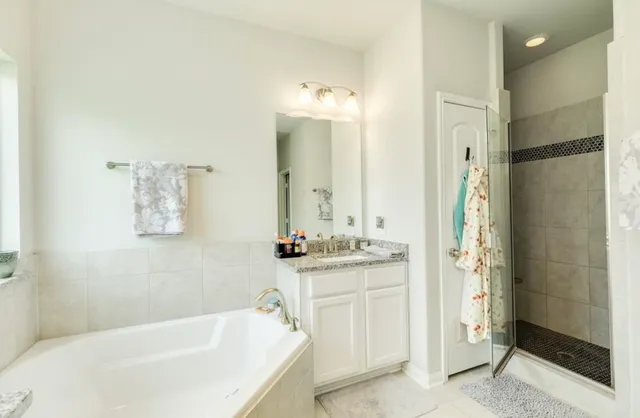 a bathroom with a tub sink and mirror