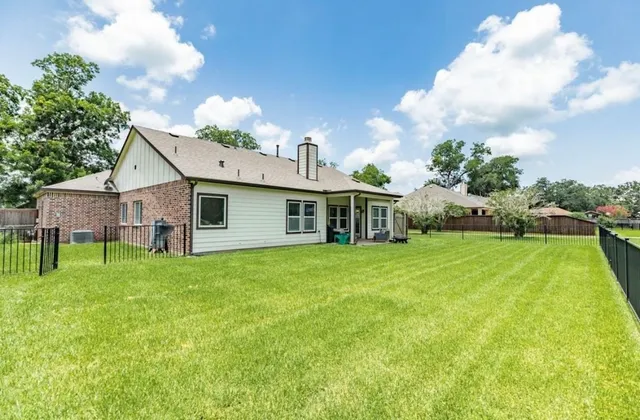 a view of a house with backyard and a garden