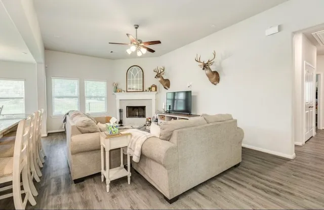 a living room with furniture a fireplace and a chandelier