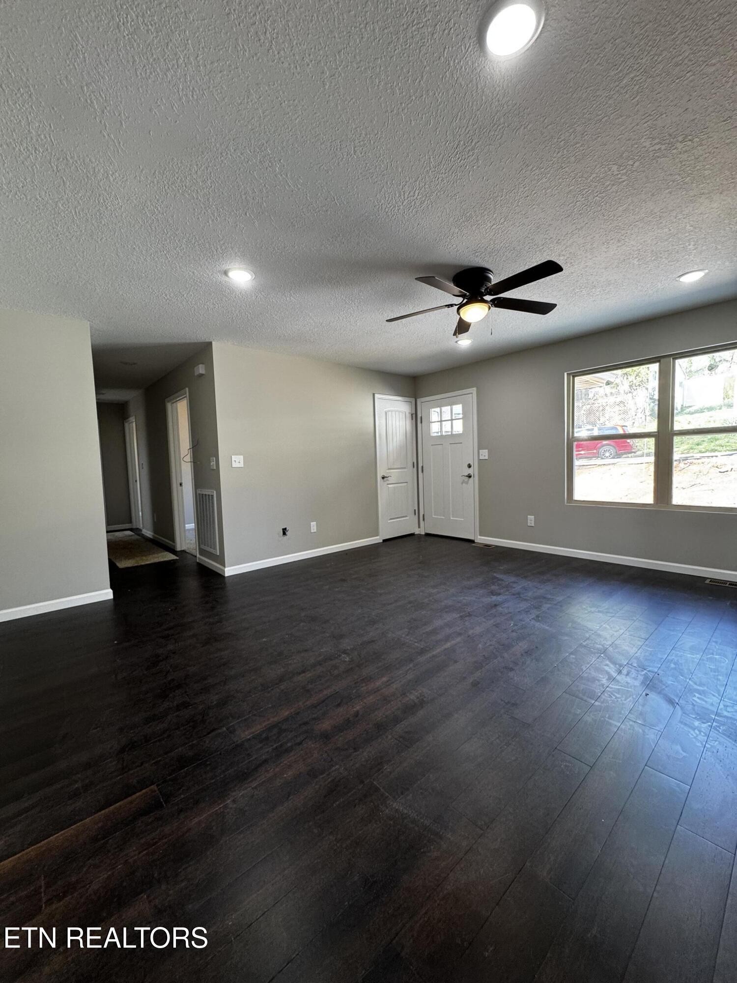 129 East Wadsworth Circle Oak Ridge, TN 37830 - Photo 4 of 13 an empty room with wooden floor and windows