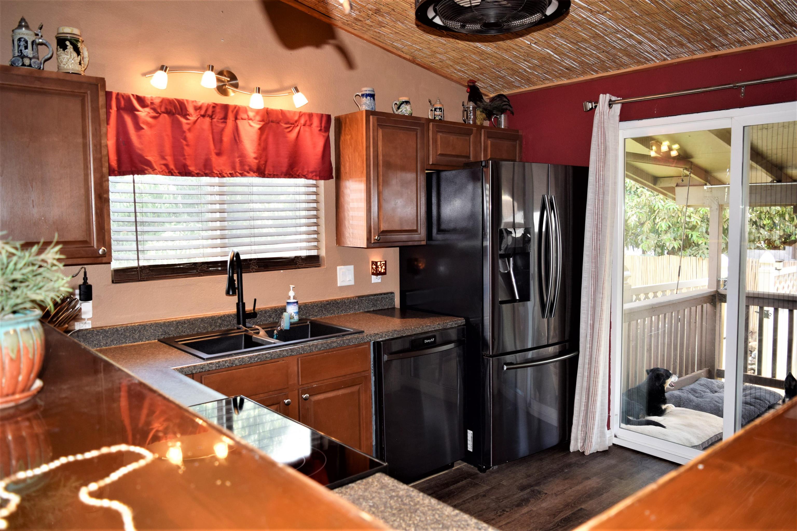 225 Humupea Street Kihei, HI 96753 - Photo 16 of 28 a kitchen with stainless steel appliances kitchen island granite countertop a sink refrigerator and microwave
