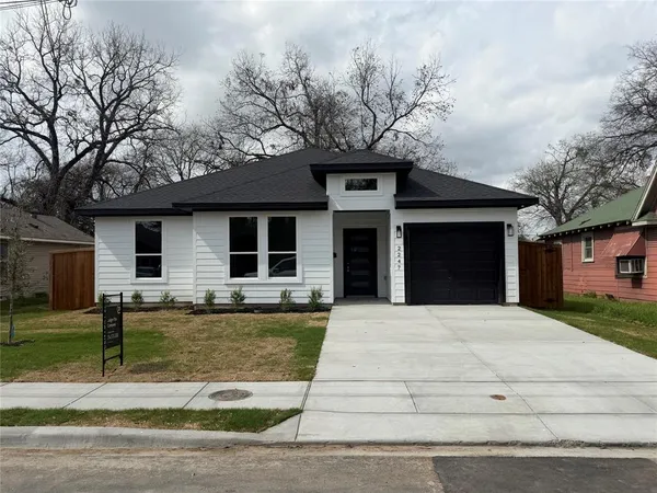 a front view of a house with garden and trees