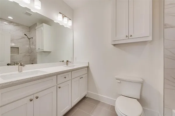 a bathroom with a toilet sink and mirror