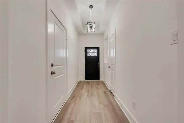 a view of a hallway with wooden floor and entryway