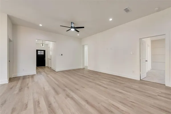 a view of empty room with wooden floor and ceiling fan