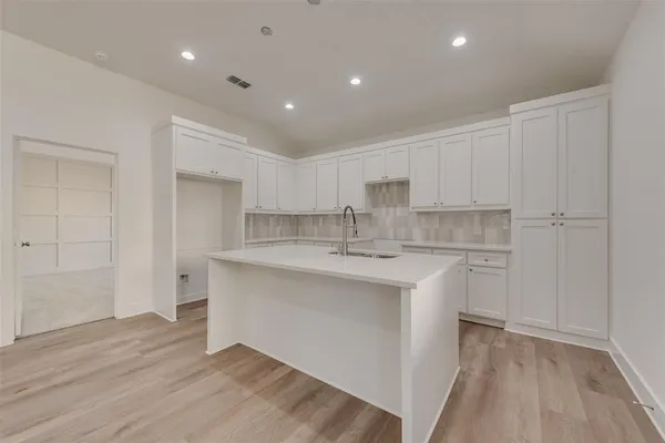 a kitchen with kitchen island a sink stainless steel appliances and cabinets