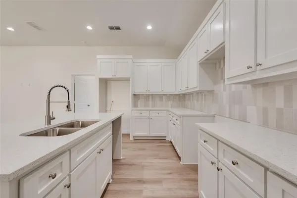 a kitchen with white cabinets a sink and dishwasher
