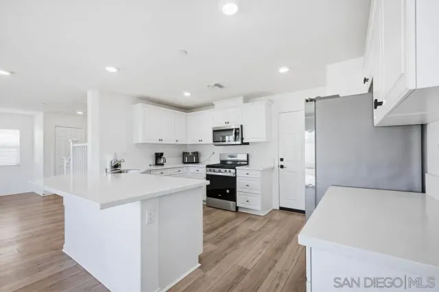 a kitchen with cabinets stainless steel appliances and a sink