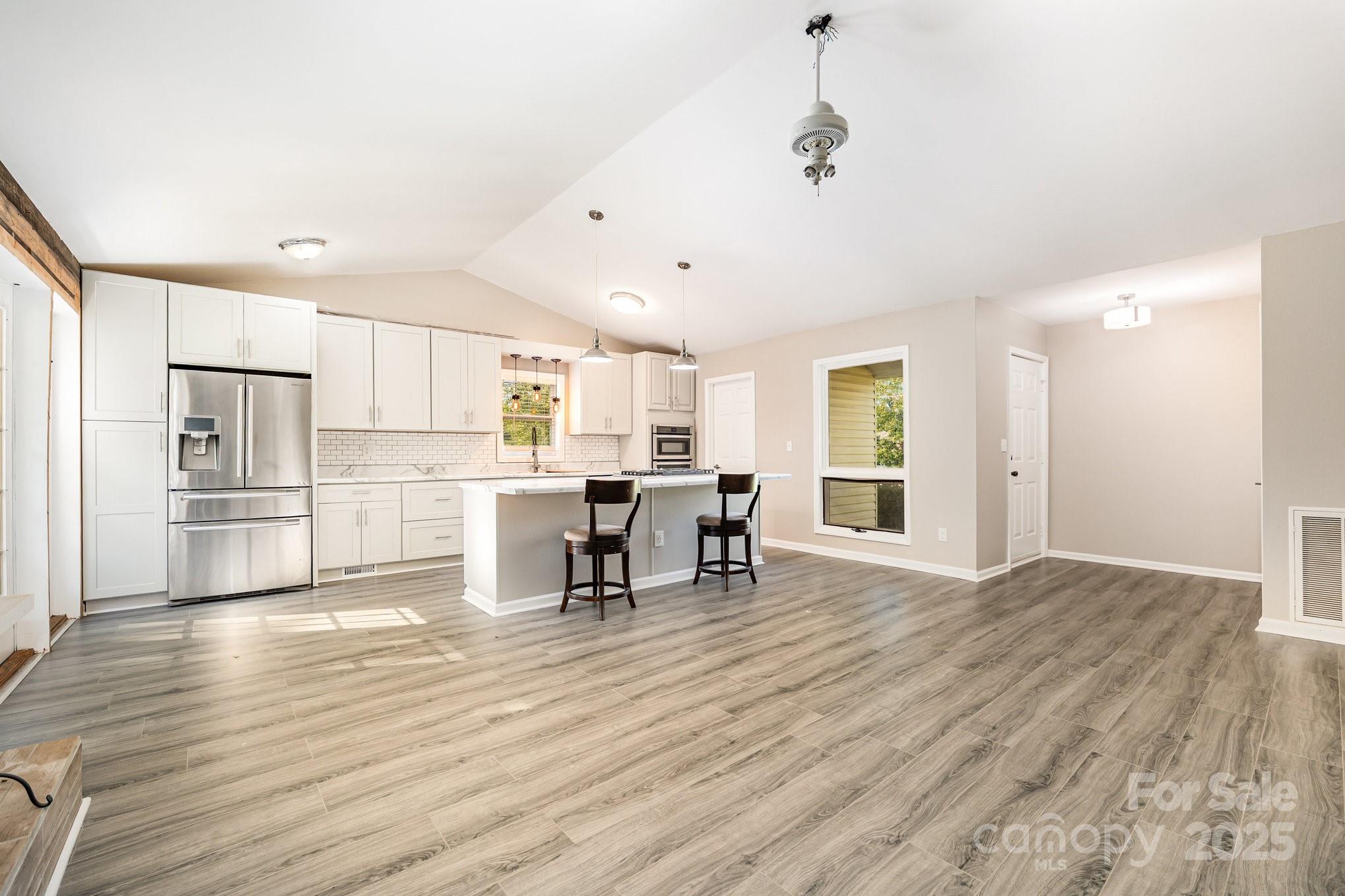 152 Sparrow Road Statesville, NC 28625 - Photo 17 of 28 a kitchen with stainless steel appliances refrigerator wooden floor dining table and chairs
