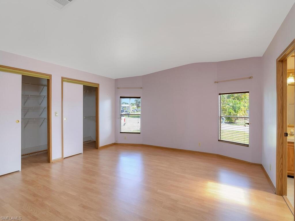 269 Riverwood Road Naples, FL 34114 - Photo 17 of 32 an empty room with wooden floor and windows